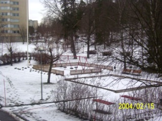 Bild på en lekplats och träd i snö