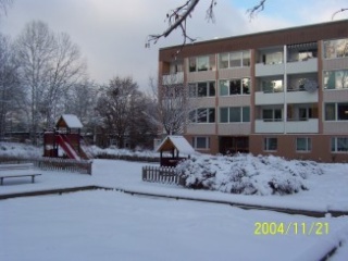 Bild på husen och en lekplats i snö