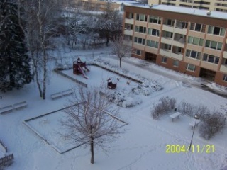 Satellitbild på husen, lekplatsen och träd i snö
