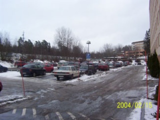 Bild på husen och en parkering med många bilar i snö